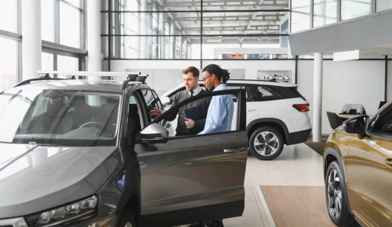 Car-Dealer-Showing-Customer-Car Car Dealer Showing Customer Car