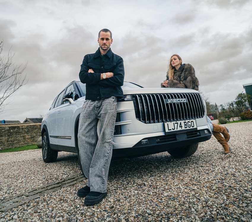 A man and a woman leaning on car for video content